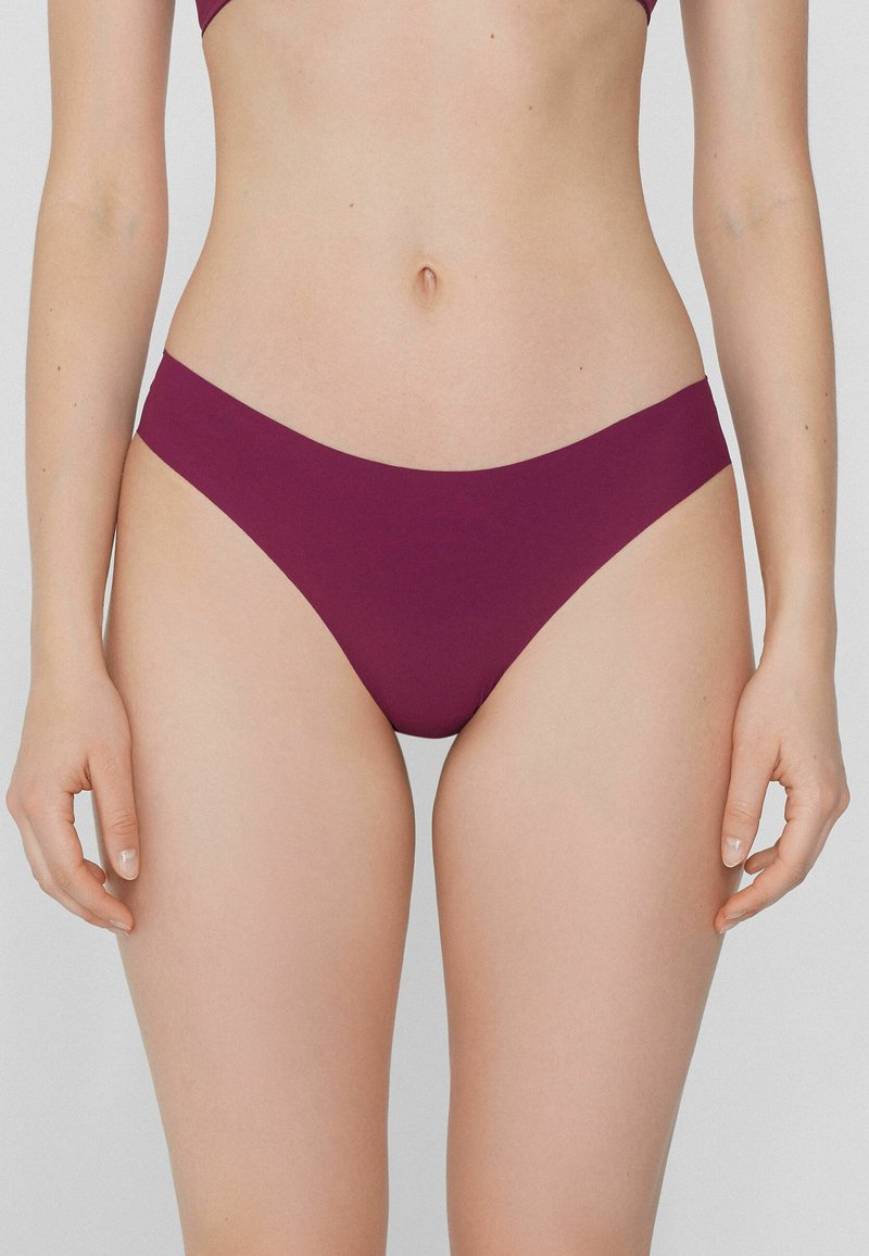 Burgunderfarbene Bikini-Hose mit einem glatten, nahtlosen Design, tief geschnitten und mit moderater Hinteransicht. Weicher, dehnbarer Stoff.