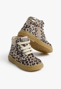 Stivali alla caviglia con stampa leopardata in tessuto beige, dettagli in metallo dorato, lacci beige e suole in gomma. Presentano una cerniera laterale per una facile calzata.