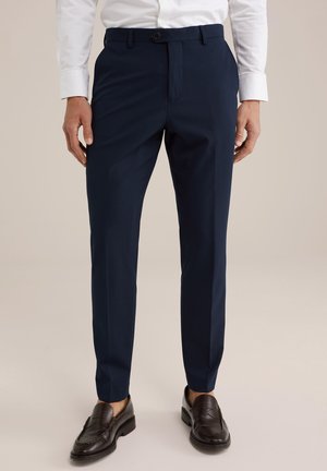 Navy blue tailored trousers with a smooth texture, slim fit, and front crease details, paired with brown leather loafers.