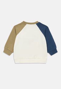 Felpa con maniche raglan nei colori crema, khaki e blu navy, caratterizzata da una morbida texture in cotone e polsini e scollatura a costine.