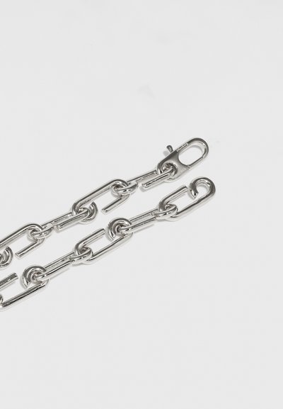 Silver metal chain with elongated links and a clasp. The surface is shiny and smooth, reflecting light against a white background.