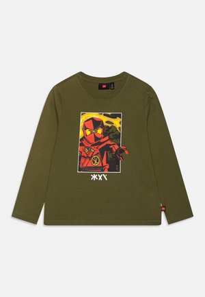 Langärmliges olivgrünes T-Shirt mit einem roten Ninja-Graphic und gelben Akzenten sowie einem weißen Druck darunter, aus weichem Baumwollmaterial gefertigt.