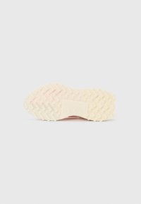 Kumin rubber sneaker sole in cream color with zigzag tread pattern. Features a central logo and textured grip for improved traction.