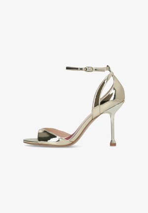 Glänzender, metallischer goldener Stiletto-Sandalette mit Knöchelriemen und offenem Zehenbereich, glatter Oberfläche und mittelhohem, schlankem Absatz.