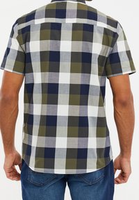 Korte mouwen overhemd met een geruit patroon in marineblauw, olijfgroen, grijs en wit. Gemaakt van lichte stof met een rechte zoom.