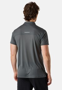 Grå kortärmad polo skjorta med fukttransporterande tyg, med en subtil randig textur och en logga på ryggen.