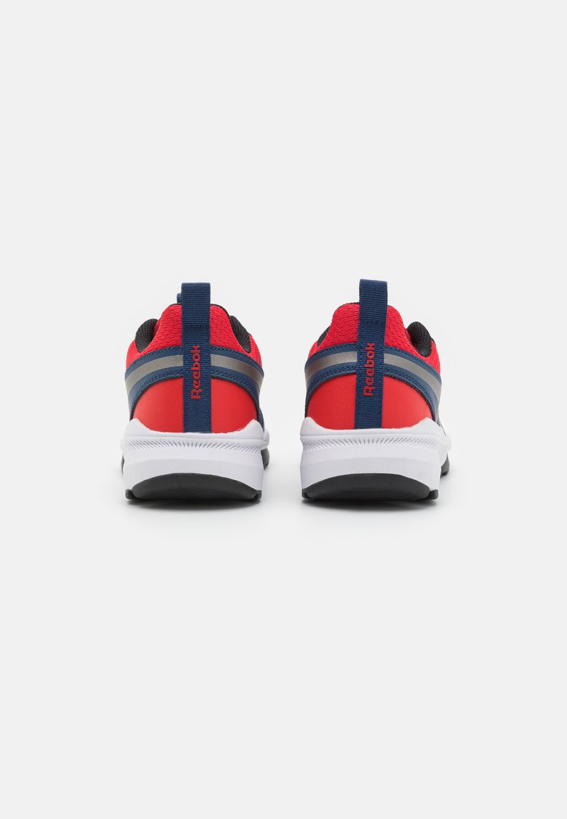 Des chaussures de sport rouges et noires avec une tige en mesh, des accents navy et des semelles blanches. Elles sont équipées d'une languette arrière et d'une semelle extérieure en caoutchouc texturée.
