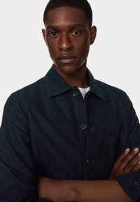 Marineblauwe button-up shirt van katoen, met een kraag, borstzak en lange mouwen. Glad textuur met minimale stikdetails.