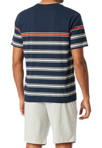 Camiseta de manga corta en color navy con rayas horizontales en blanco, gris y naranja. Combinada con pantalones cortos de color gris claro. Material de algodón, corte casual.