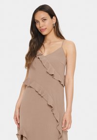 Rochie maro dintr-un material ușor, având accente volănate pe față, cu bretele subțiri și un design fluid.