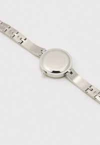 Sølvfarvet armbåndsur i rustfrit stål med rund urkasse, glat overflade og ledet rem. Har en krone og graveret bagside. Minimalistisk design.