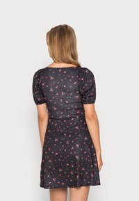 Vestido preto de mangas curtas com corpete ajustado e saia ampla, adornado com pequenos padrões florais em rosa. Tecido suave e silhueta clássica.