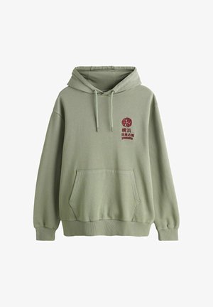 Gaiši zaļa kapuce ar priekškabatu un sarkaniem japāņu rakstzīmēm un apaļu dizainu uz kreisās krūtis.