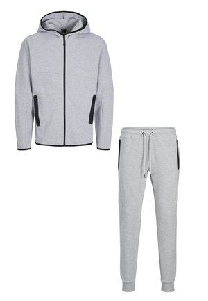 Lichtgrijze capuchonvest met ritssluiting en bijpassende joggingbroek met zwarte ritszakken en trekkoord in de taille.