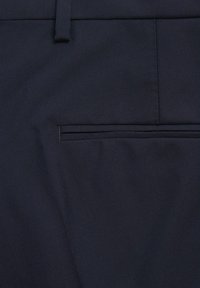 Navy blue materiał szczegół spodni ze stanu z małą, wyszywaną kieszonką z subtelnym fałdem. Gładka tekstura z dopasowanym wykończeniem.