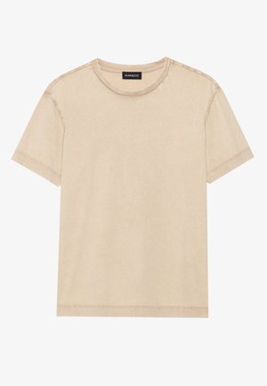 Kortermet beige t-skjorte laget av mykt stoff. Har en rund hals og synlig søm langs kantene. Enkel og minimalistisk design.