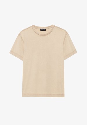 Beżowy t-shirt z krótkim rękawem wykonany z miękkiej tkaniny. Posiada okrągły dekolt i widoczne szwy wzdłuż krawędzi. Prosty i minimalistyczny design.