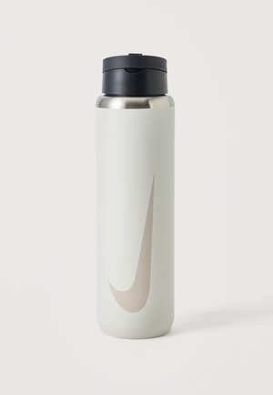 Grande bouteille d'eau réutilisable blanche avec un bouchon à clapet noir et un logo swoosh gris clair à l'avant, posée sur une surface blanche.