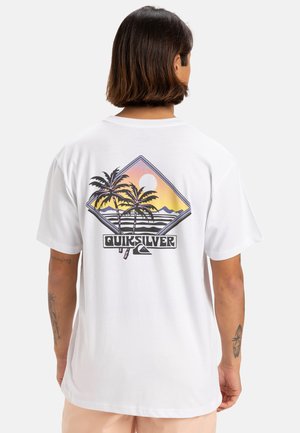 Camiseta de algodón blanca con un gráfico colorido de una palmera y un motivo de sol en la parte trasera, con el logo de "Quiksilver" en la parte inferior.