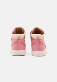 Baskets montantes en cuir rose avec semelles en caoutchouc blanc, dotées d'un accent crème au niveau du col et d'une finition lisse.