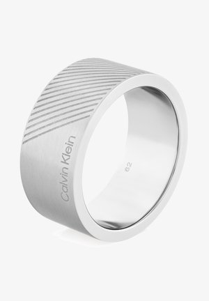 Ampio anello in argento con finitura spazzolata, caratterizzato da un motivo inciso diagonale. Inciso "Calvin Klein" e taglia "62" all'interno.