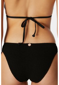 Svart bikini-set med strukturerad stickad tyg, justerbar halterneck med snören och högmidjad botten med en dekorativ knapp.