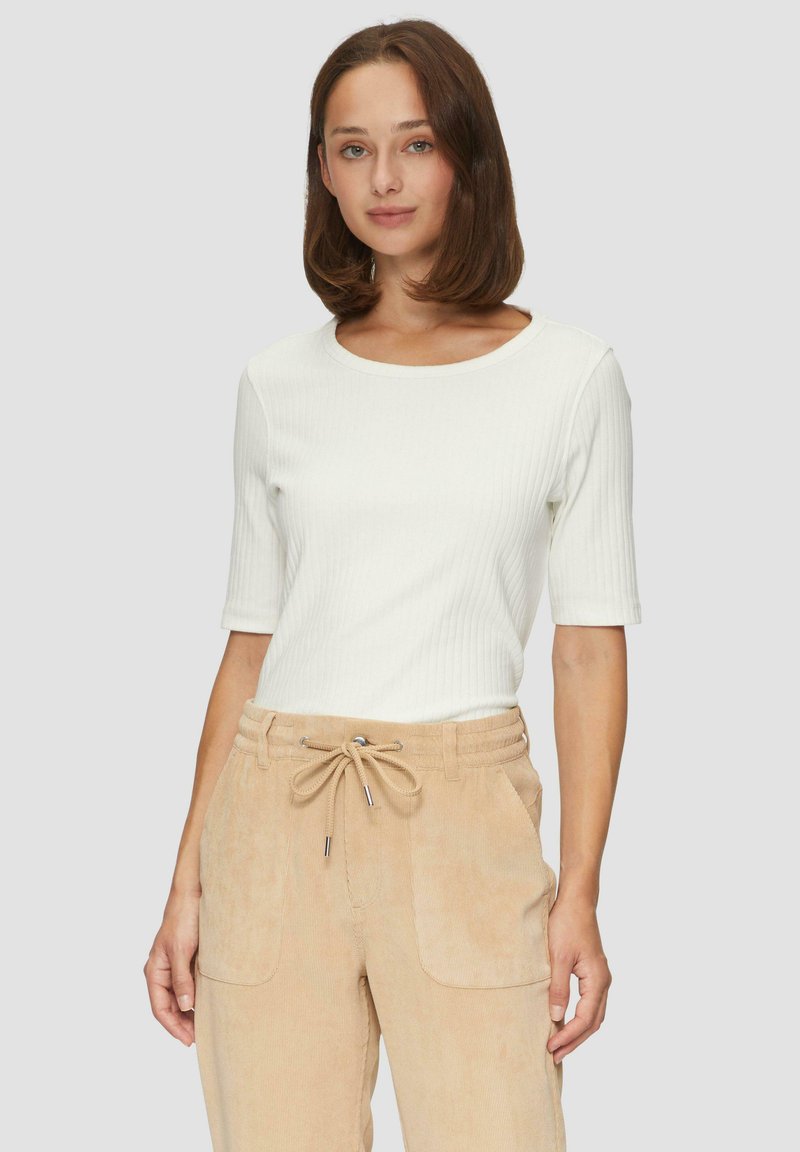 Weißes, geripptes Oberteil mit kurzen Ärmeln, kombiniert mit tanfarbenen kordelgewebten Hosen mit verstellbarem Bund und seitlichen Taschen. Glatte Textur, figurbetontes Design.