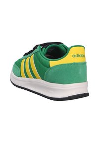 Sneaker verde Adidas con strisce gialle e linguetta del tallone, lacci neri, suola bianca contrassegnata "Cloudfoam", mostrata dal lato posteriore destro.