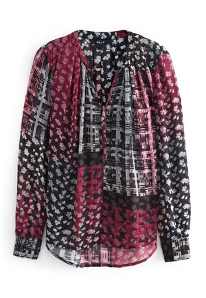 Blouse femme à manches longues avec motifs floraux et abstraits mélangés dans des tons bordeaux, noir, blanc et rose, fermeture éclair à l'avant et ourlet arrondi.