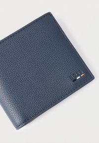 Portafoglio in pelle blu navy con finitura testurizzata, bordi cuciti e logo in rilievo con tre accenti colorati: nero, bianco e arancione.