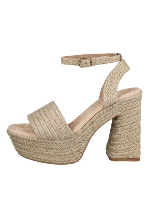 Sandalia de plataforma beige tejida con correa en el tobillo y tacón ancho alto, con textura trenzada en todo el zapato.