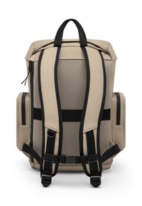 Beige hátizsák, texturált hálós hátrésszel, fekete pántokkal és csatos részletekkel. Oldalsó zsebekkel és a tetején található fogantyúval rendelkezik a könnyű hordozhatóság érdekében.