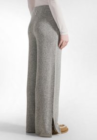 Grijze geribde broek van zachte stof, met een hoge tailleband en zijsplitten aan de zoom. Gepaard met pluizige pantoffels.