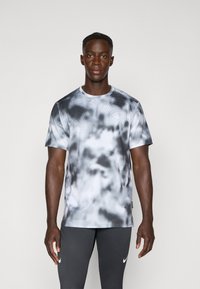 Men's short-sleeve athletic shirt in grey and white tie-dye pattern. Features a round neckline and textured fabric with small perforations.