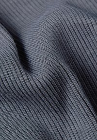 Hall grey ribbed kangast, millel on pehme tekstuur ja vertikaalsed jooned. Materjal näib veniv ja siledana, omades peent sära ja sügavust.
