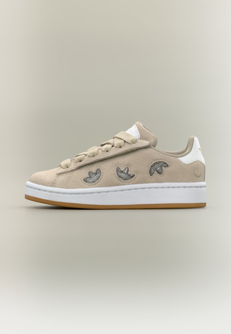 Bézs színű, velúrbőr sneaker három hímezett levélmintával, lapos fűzővel, gumitalppal és fehér sarokkal. Oldalán texturált díszítéssel.