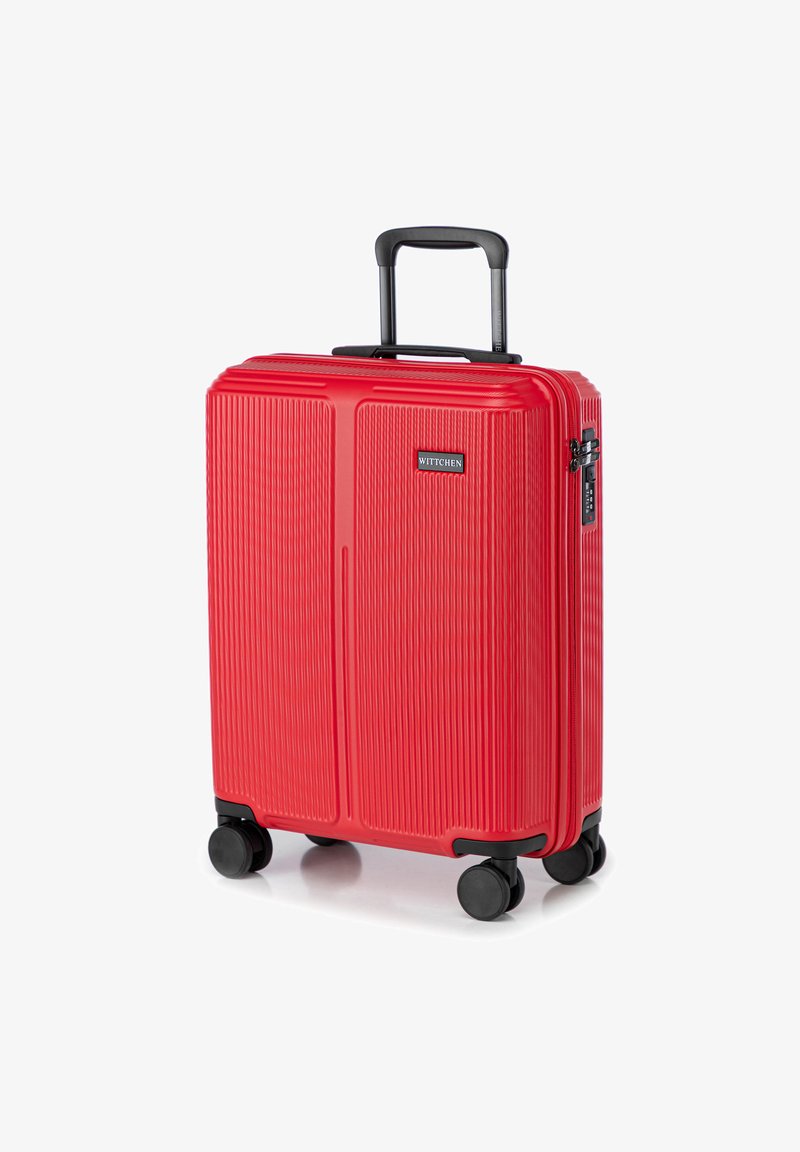 Červený tvrdý kufr s jemně vroubkovaným povrchem, teleskopickou rukojetí a čtyřmi černými kolečky. Na boku se nachází kombinovaný zámek.