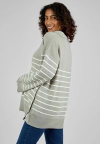 Helles grauer, gestrickter Pullover mit weißen horizontalen Streifen, ausgestattet mit einem gerippten Saum und seitlichen Schlitzen für mehr Bewegungsfreiheit.