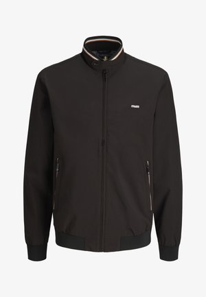 Fekete cipzáras dzseki álló gallérral, csíkos szegéllyel, két cipzáras oldalzsebbel, elasztikus mandzsettával és szegéllyel, valamint egy kis logóval a mellkasnál.