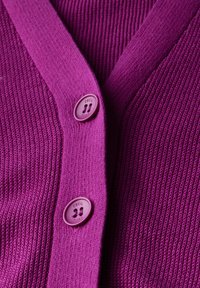 Paarse gebreide cardigan met een V-halsontwerp en twee ronde knopen met de merknaam "Cecil." De textuur is geribbeld met gladde accenten.