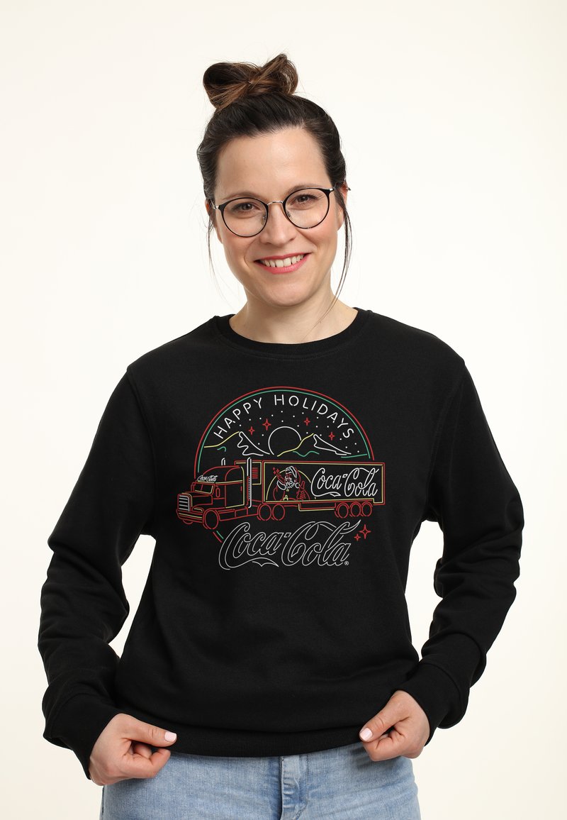 Felpa nera con una grafica natalizia colorata della Coca-Cola che presenta un camion, montagne ed elementi festivi. Vestibilità comoda e maniche lunghe.