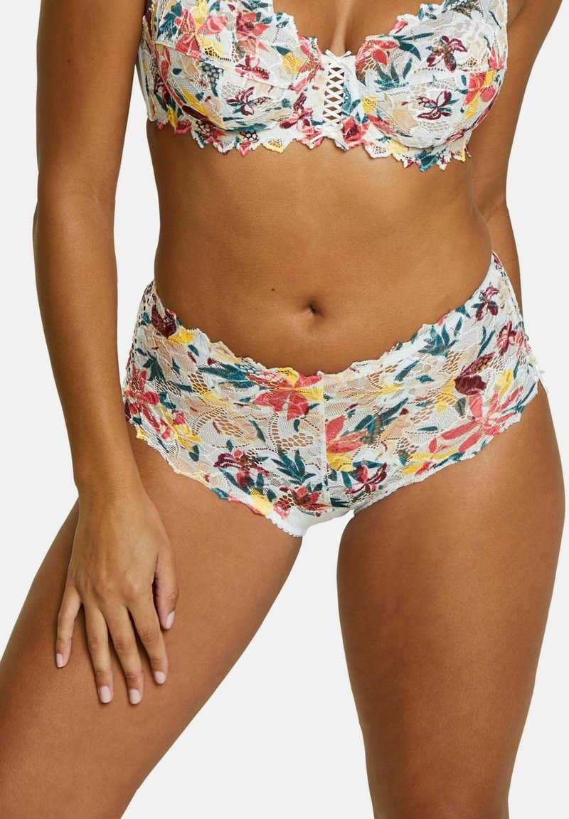 Lace bralette and matching shorts set featuring a floral pattern in red, yellow, and green on a white background with scalloped edges.