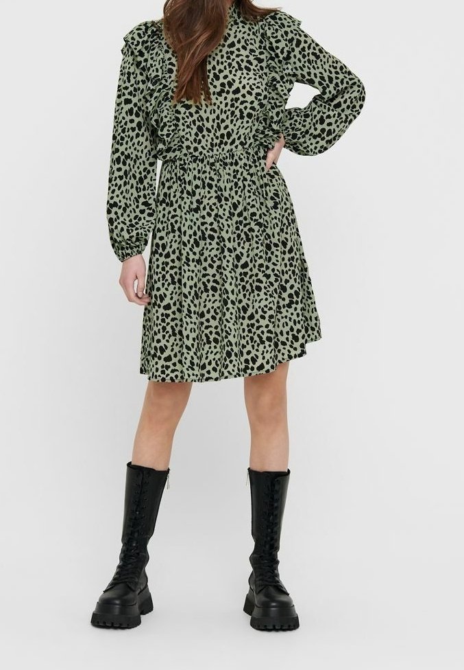 Robe verte à imprimé léopard avec manches à volants, taille cintrée et jupe évasée. Associée à des bottes de combat noires à lacets.