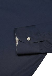 Camicia a maniche lunghe blu navy con fodera a scacchi contrastante nei polsini e design del polsino rotondo, caratterizzata da una chiusura con bottoni e texture del tessuto liscia.