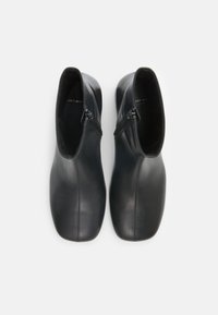 Black leather ankle boots with a sleek design, featuring a side zipper and smooth texture. Rounded toe and minimal stitching detail.