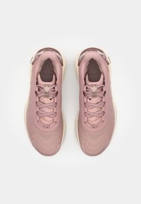 Zapatillas deportivas rosas con un upper de textil suave, patrones intrincados y suelas de goma crema. Incluyen cordones y un collar acolchado.