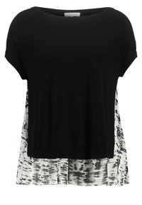 Mustahiin lyhyet hihat mustassa yläosassa, jossa on rento malli, takaosassa läpinäkyvä valkoisen ja mustan kuvioitu kangas, ja suora helma.