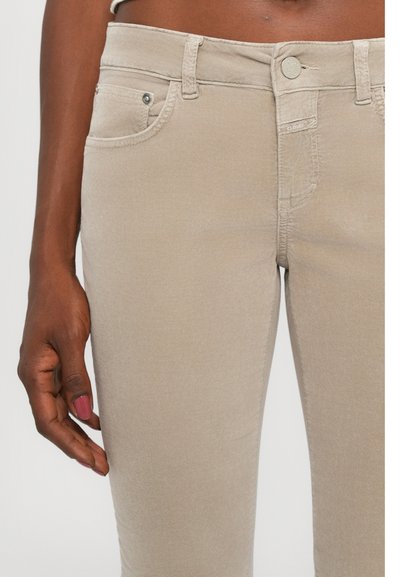 Béžové denimové džínsy so slim fit strihom, s klasickým päť-pocket dizajnom, kovovým zapínaním a jemnými vyšívanými detailmi.