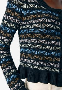 Cardigan en tricot avec un motif géométrique bleu, marron, rose et crème sur fond noir, avec un ourlet volanté et une fermeture à boutons.