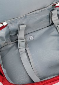 Červený sportovní batoh s šedým interiérem, s šedými popruhy, se zipovým uzávěrem a diskrétním vlnkovým vzorem na podšívce.